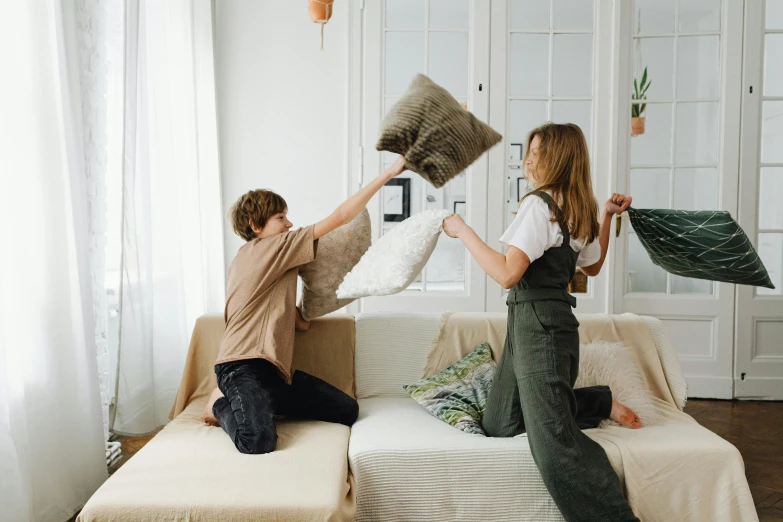 two people that are setting up the pillows for the couch