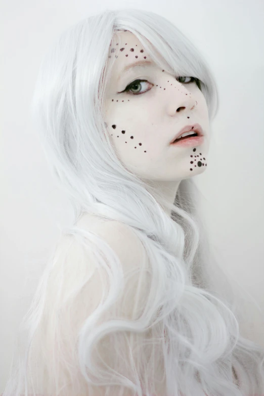 woman with white hair and black dotted makeup