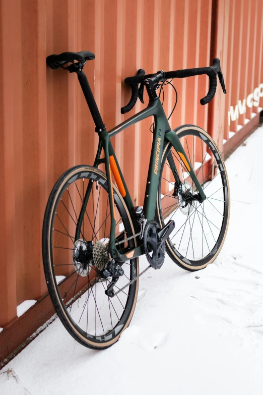 a bicycle is hanging on the wall near snow