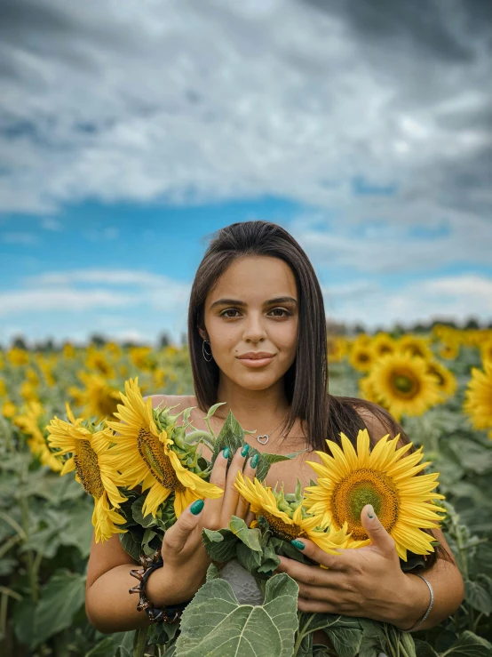 a girl with long hair holding up two yellow flowers