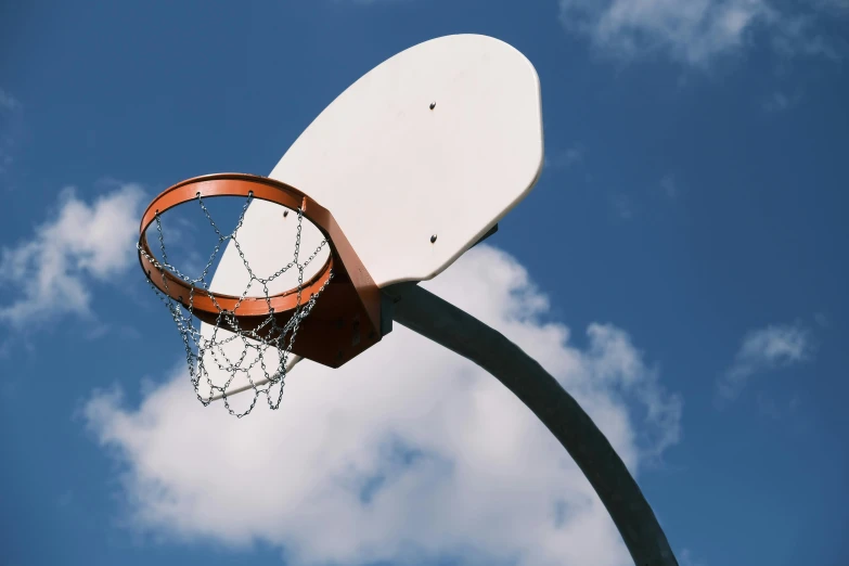 a close up of a basketball net and basketball hoop with the sky in the background