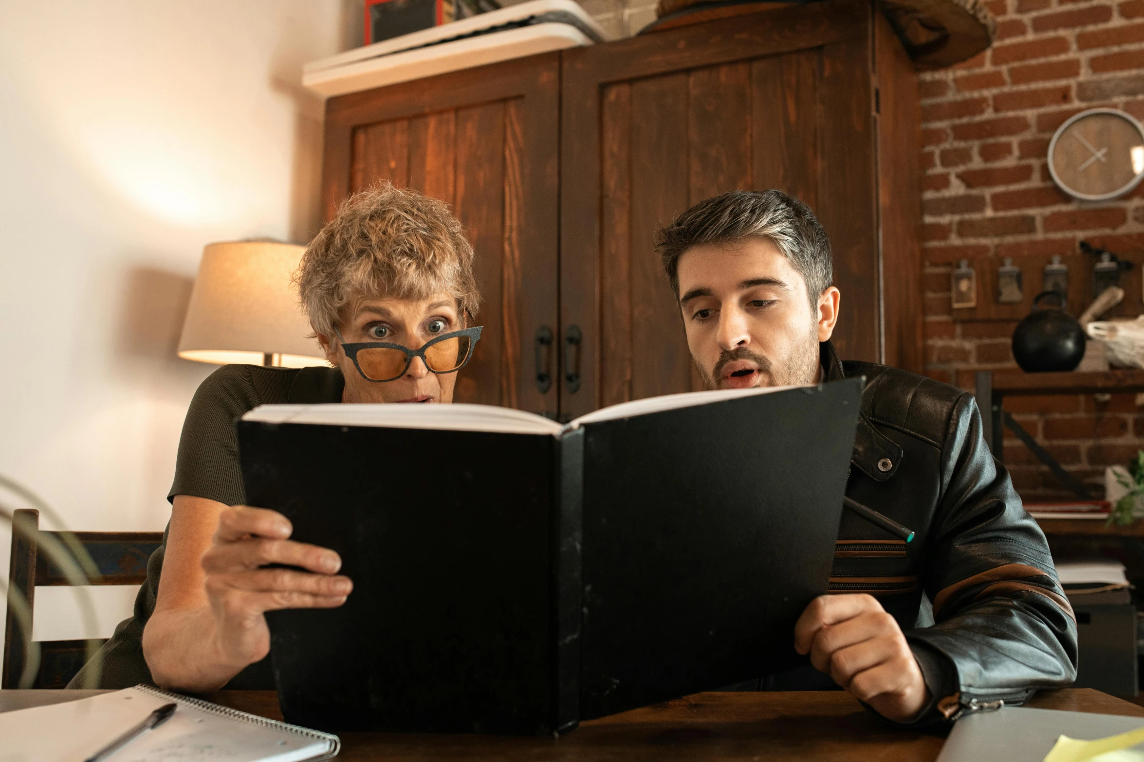 two people reading a book at the table