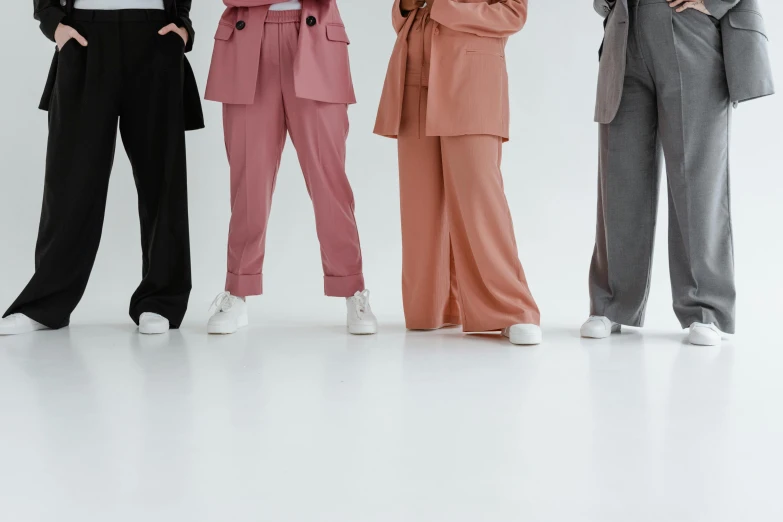 four people wearing wide legged pants and blazers