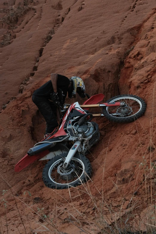 a person kneels down next to their bike in the sand