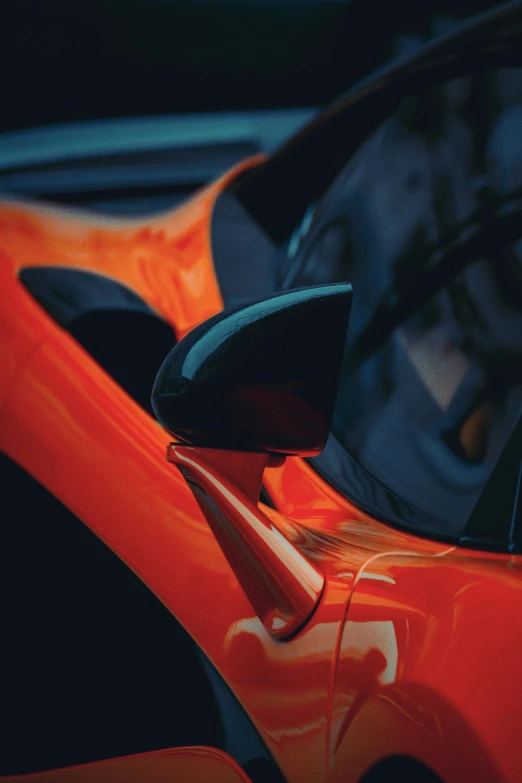 close up of orange sports car in parking lot