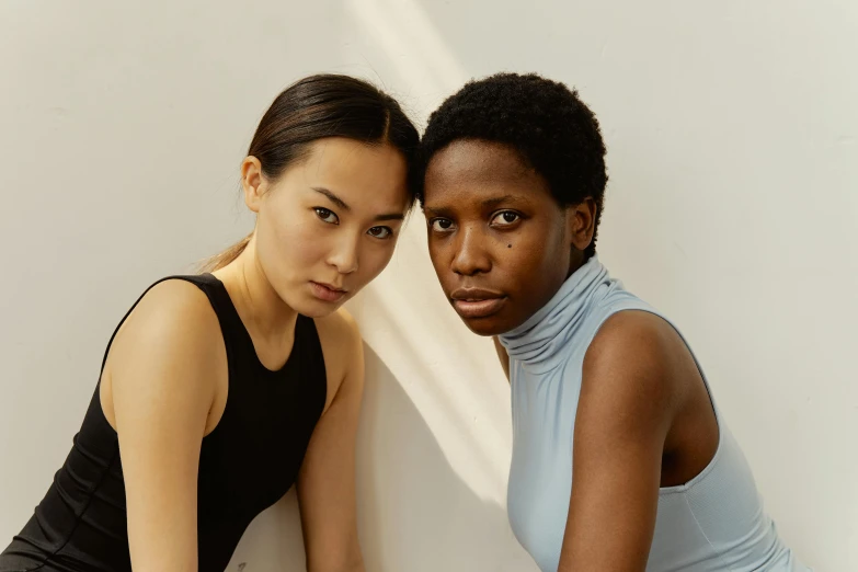 two women posing for the camera, posing with their arm around each other