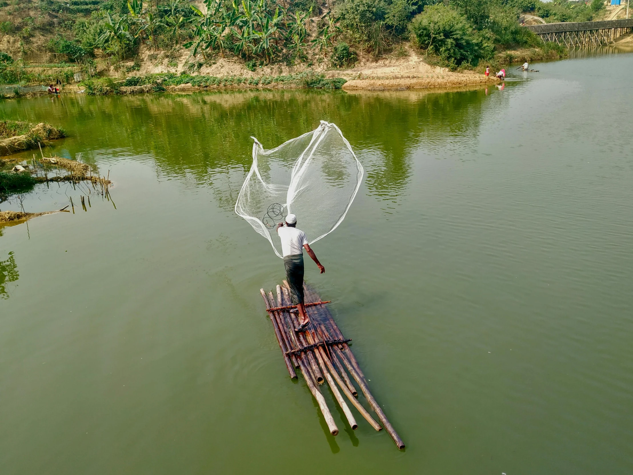 a person riding on top of a wooden raft in water