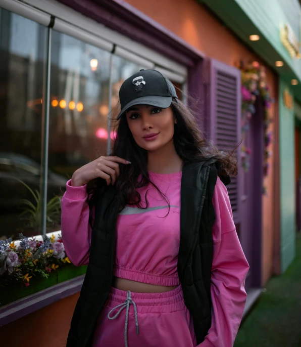 a woman in a pink dress and black hat