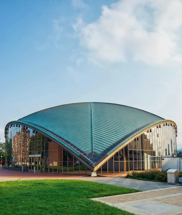 a beautiful curved building is under blue skies