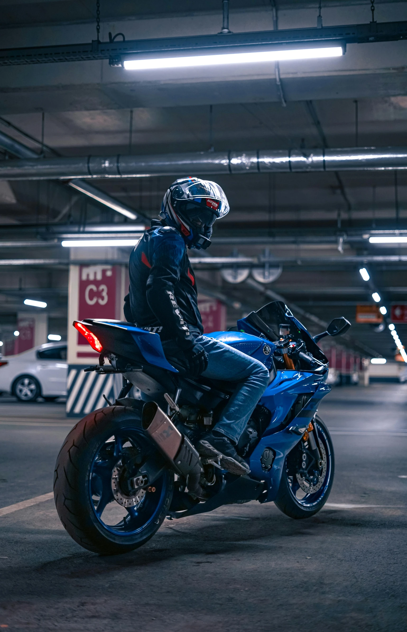 a man is riding his motorcycle in the parking garage