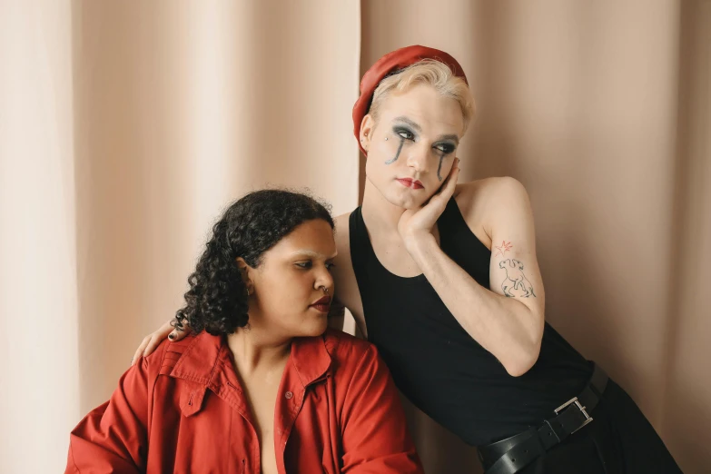 a woman with a cigarette next to her face and another woman in a black top