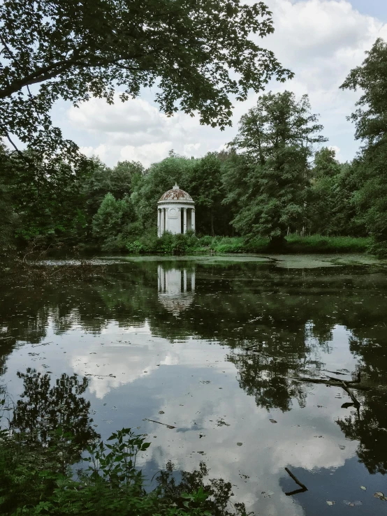 a small chapel in the middle of a large pond