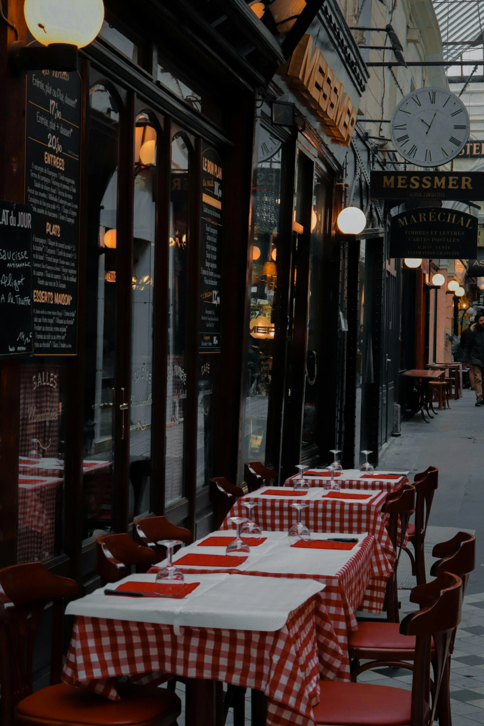 tables outside of an outdoor restaurant with red chairs and white checkered cloths