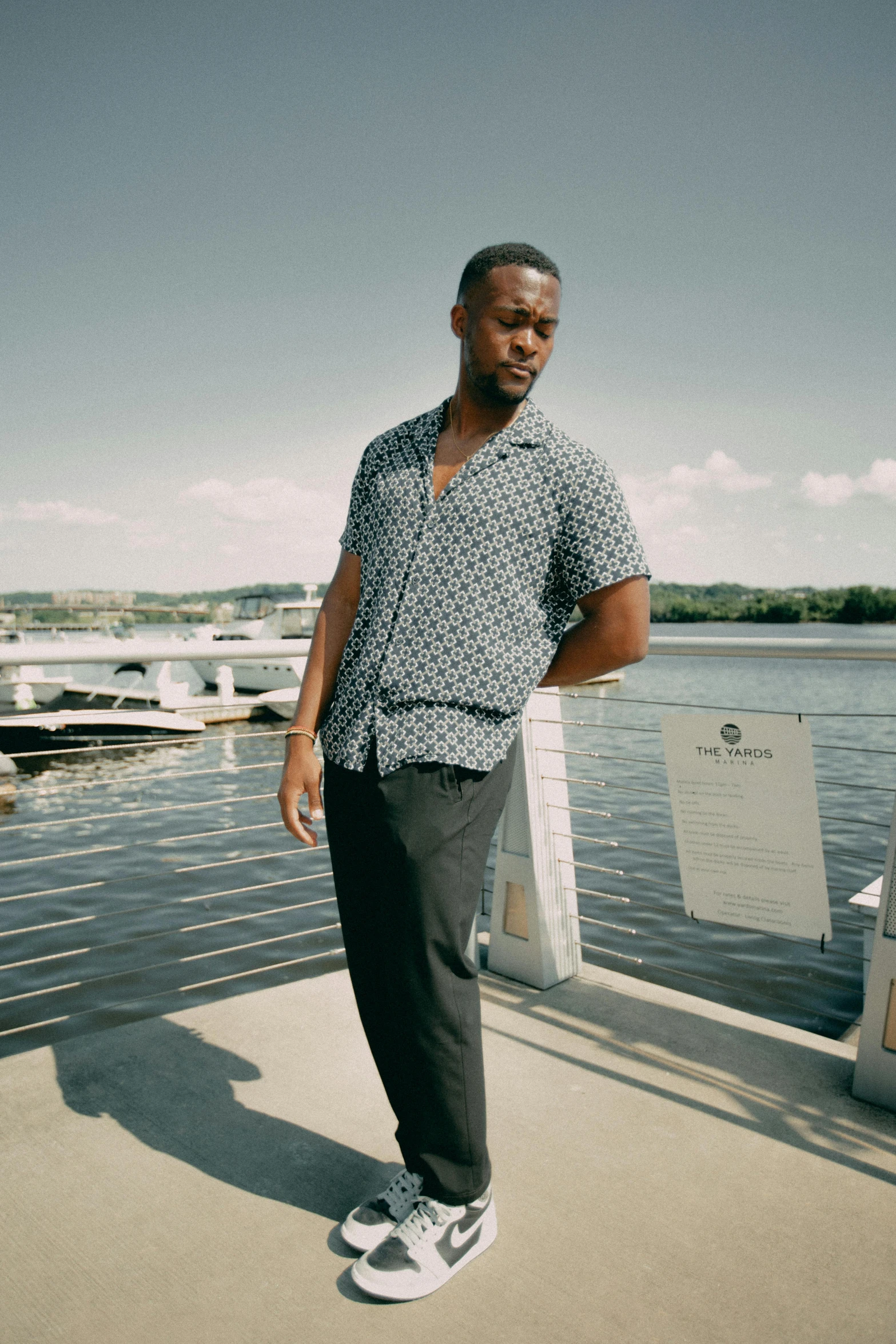 a man standing on a dock on the edge of a lake