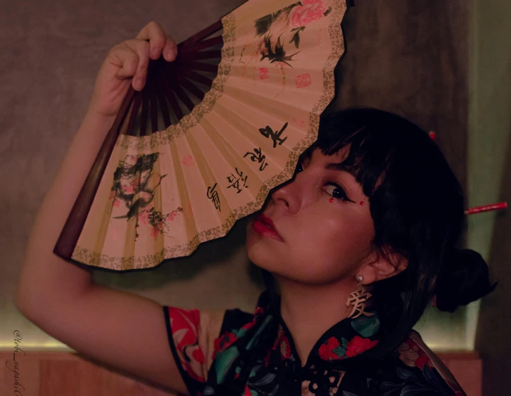 a woman wearing a floral shirt holding a decorative object