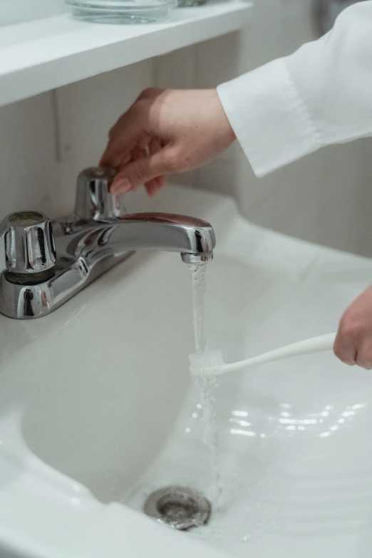 someone is washing hands in the sink