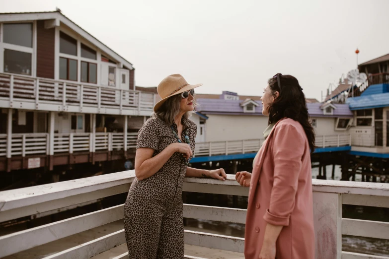 a woman in a red and black outfit talking to another woman