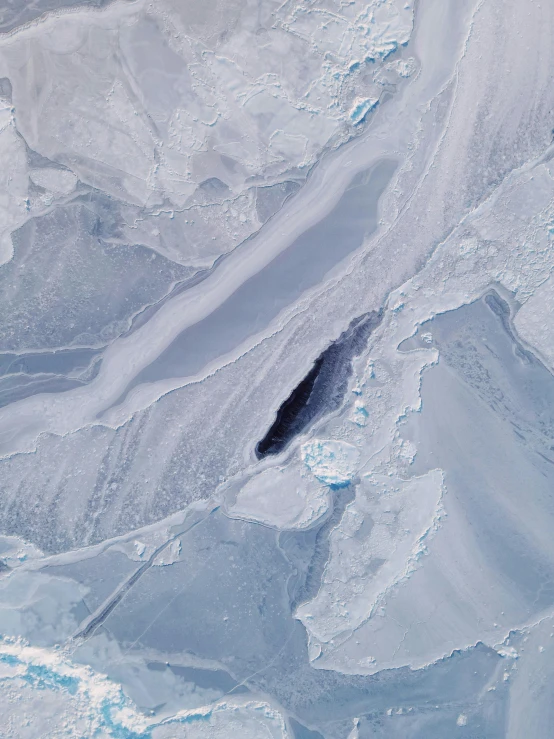 a snowy landscape showing the ice layers and black object