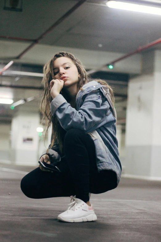 young woman sitting on floor with headphones on her ear