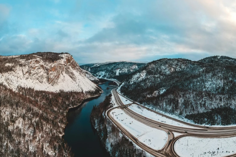 an aerial view of a snowy mountain with a highway winding through it