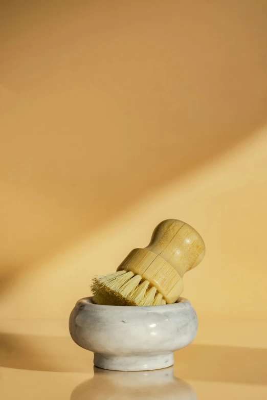 a white stone bowl with brush on top