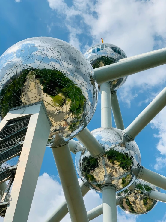 mirrored balls are positioned on top of metal poles in a park