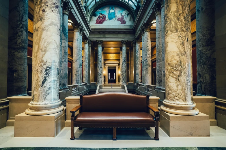 an old building with large columns and a chair on the ground