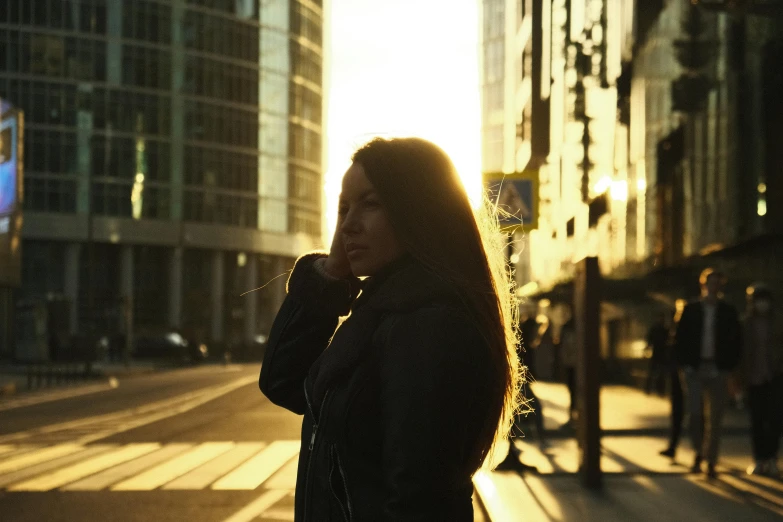 a woman walking down a sidewalk with her phone to her ear