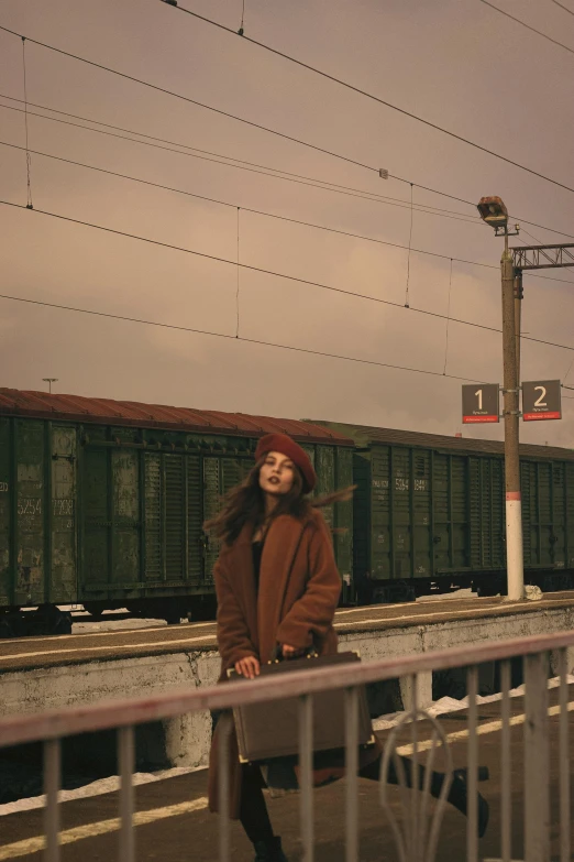 the woman is carrying her suitcase at the train station