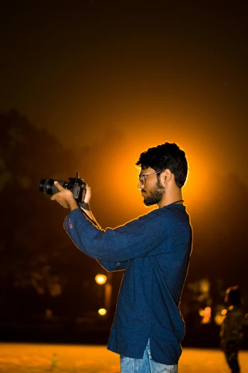 a man in a blue jacket holding up a camera
