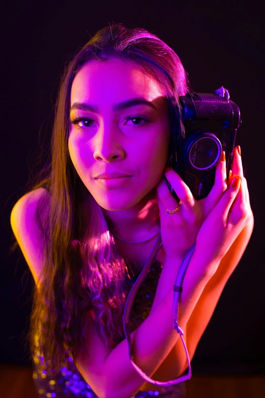 a woman holding an old fashioned camera in her hand