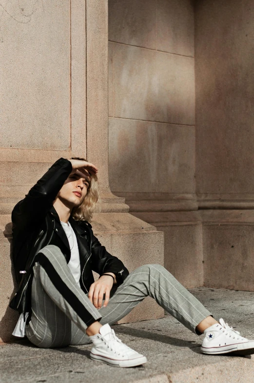 a man is sitting on the concrete outside