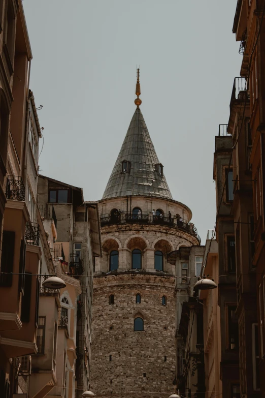 an ancient clock tower as seen from between other buildings