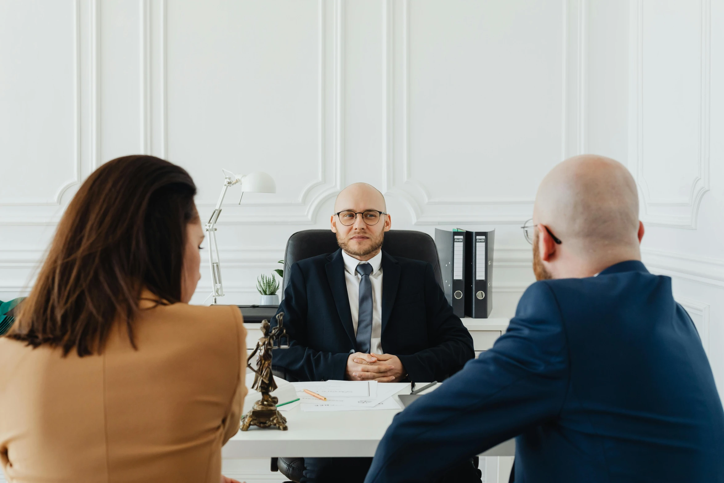 three business people sitting at a table in an office