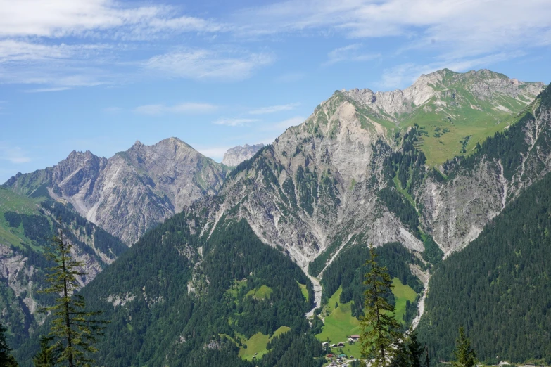 the mountains are high above the trees and houses