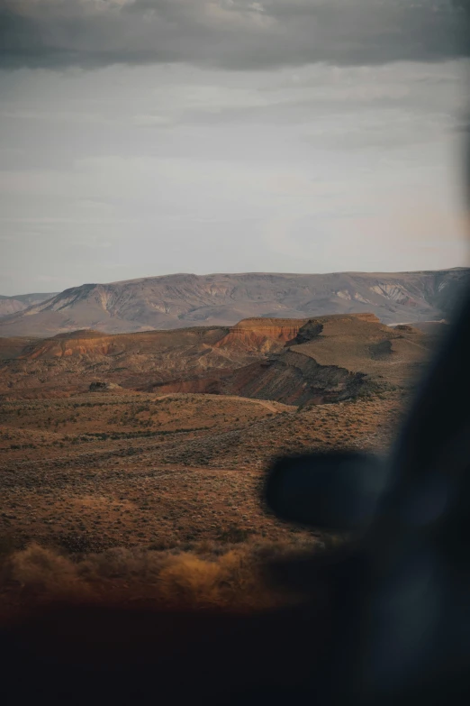 a scenic view of a valley and a small hill