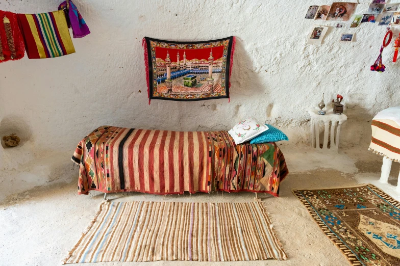 a bedroom with a bed covered in a colorful blanket