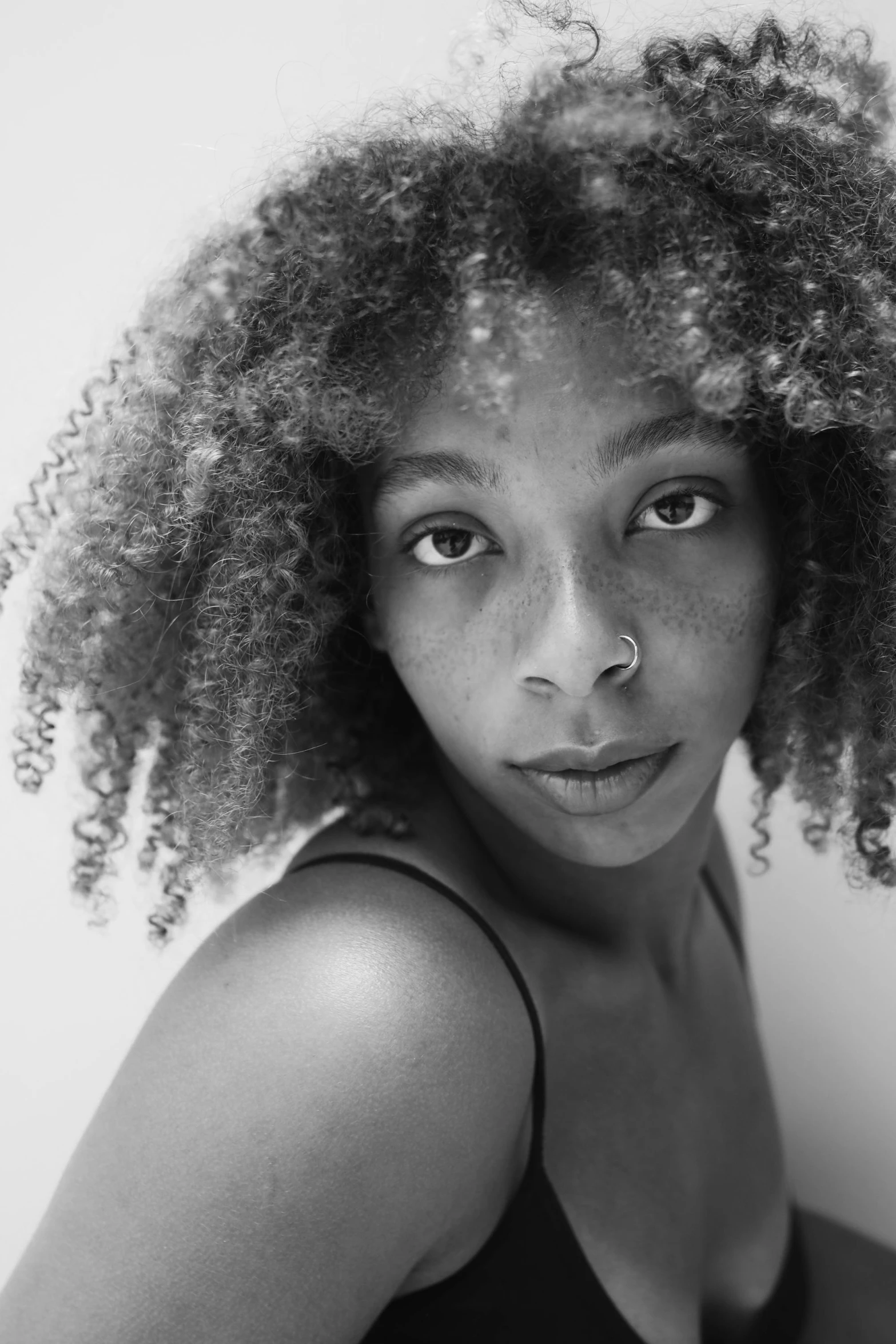 a woman wearing a tank top and some hair