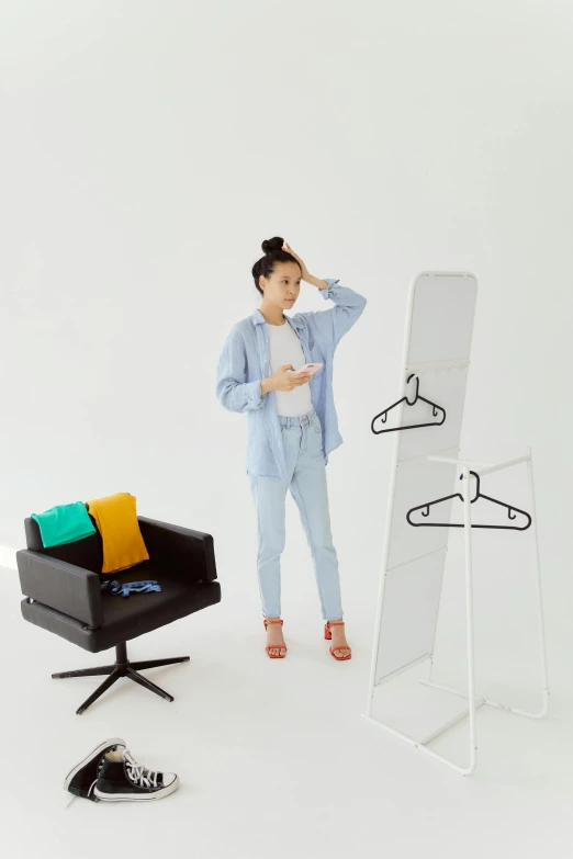 a lady holding a pair of scissors next to her clothes hanger