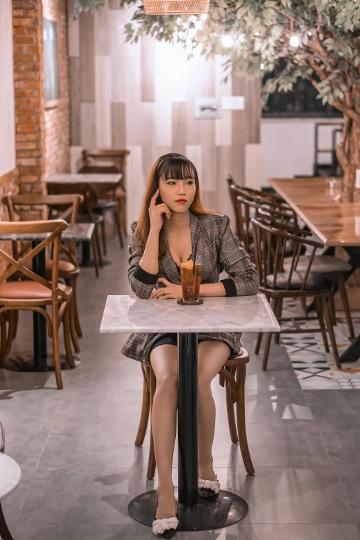 a young woman sits at a table in front of an empty vase