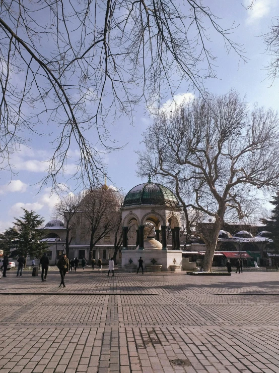 a city square with trees and people walking