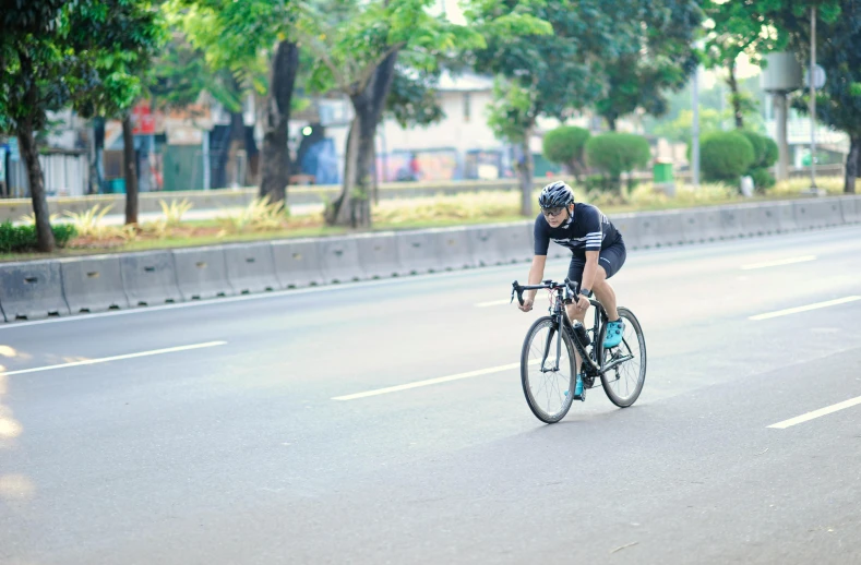 the cyclist is racing his bike down the road