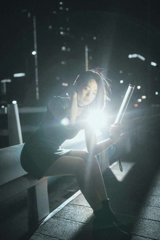 a woman sitting on a bench holding a cell phone