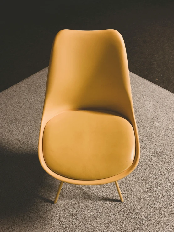 an orange chair sits on top of a carpet