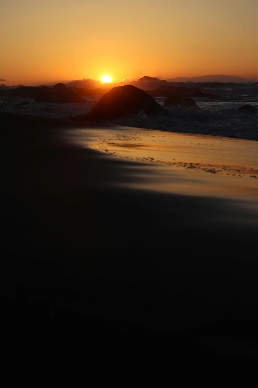 the sun rises over the horizon at sunset on the beach