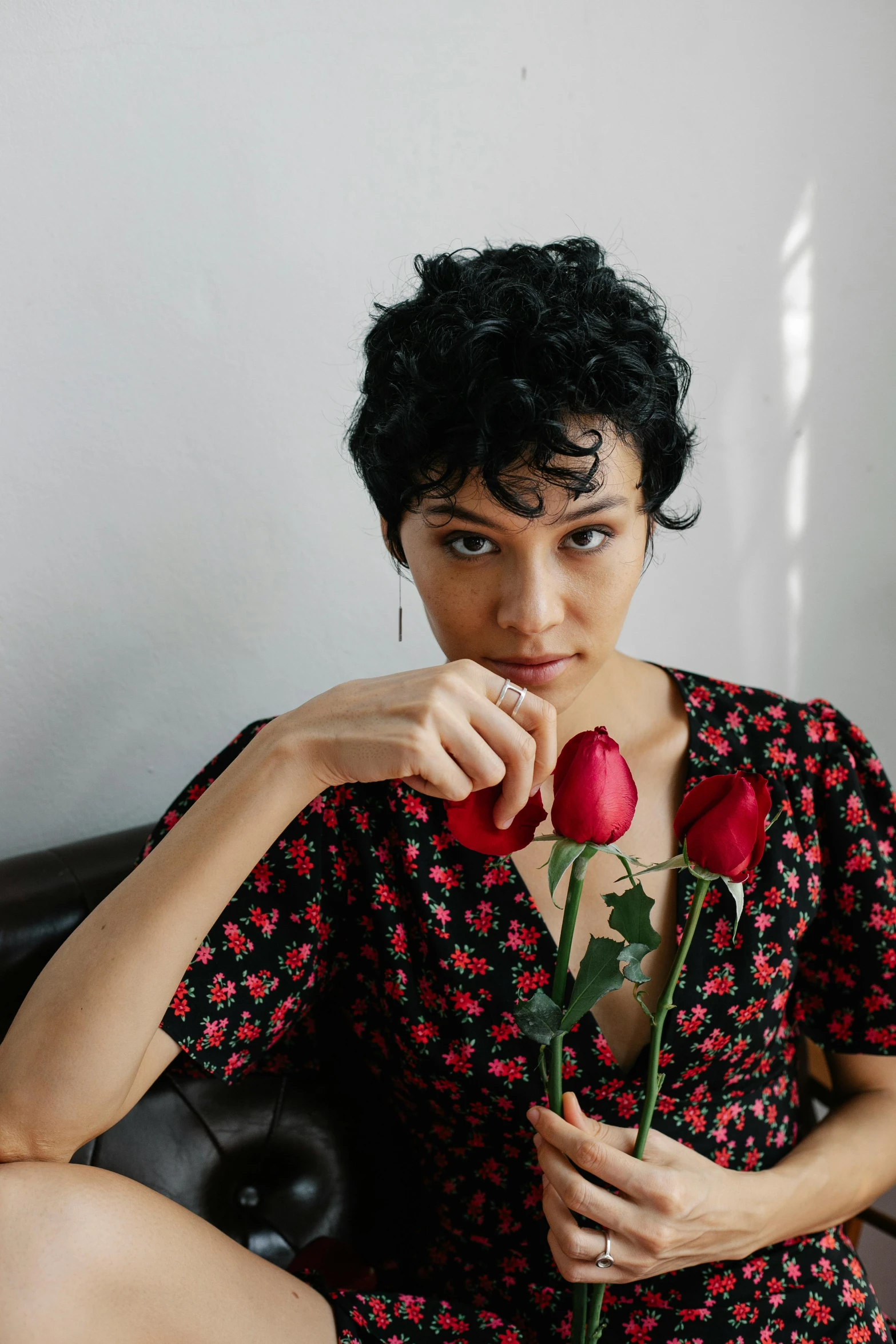 a woman holding a flower with her left hand