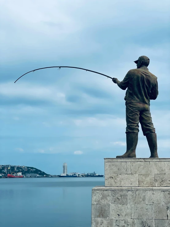 a statue holding a fish in his right hand