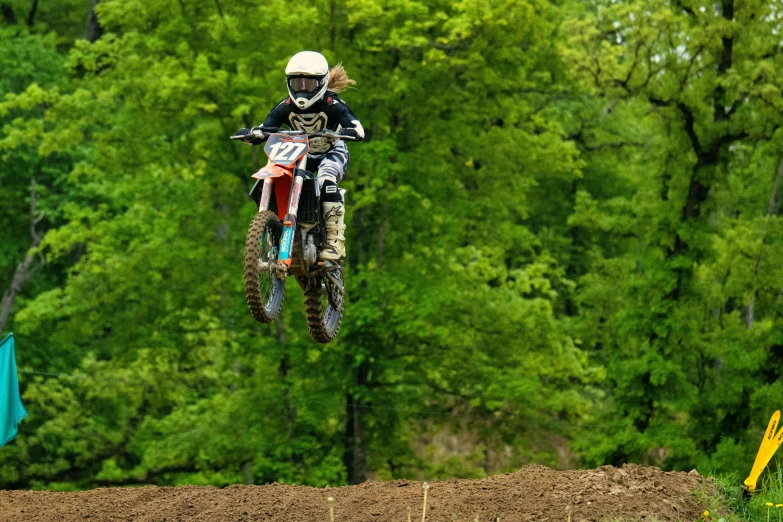 a person riding a motorcycle in the air over dirt