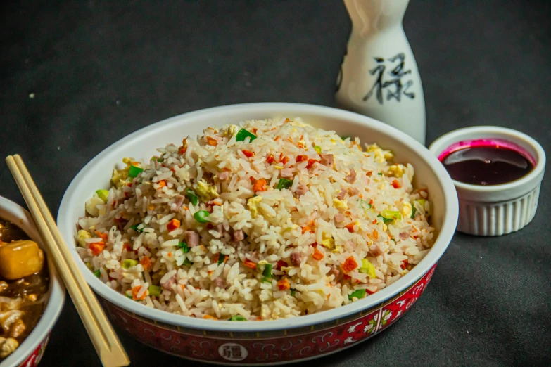 rice and sauces are on a black table