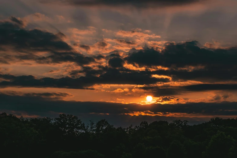 a sun is setting behind some clouds in the sky